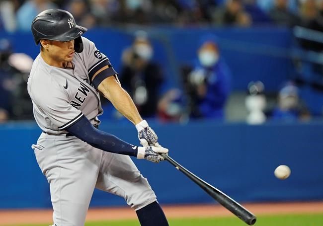 New York Yankees' Giancarlo Stanton (27) hits a three-run home run during seventh inning American League MLB baseball action against the Toronto Blue Jays in Toronto on Tuesday, September 28, 2021. THE CANADIAN PRESS/Frank Gunn