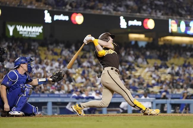 San Diego Padres' Jake Cronenworth, right, hits a solo home run as Los Angeles Dodgers catcher Will Smith watches during the ninth inning of a baseball game Tuesday, Sept. 28, 2021, in Los Angeles. (AP Photo/Mark J. Terrill)