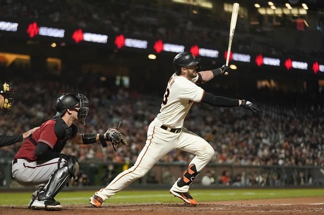 San Francisco Giants' Kris Bryant, right, hits a sacrifice fly in front of Arizona Diamondbacks catcher Carson Kelly that scored Steven Duggar during the seventh inning of a baseball game in San Francisco, Wednesday, Sept. 29, 2021. (AP Photo/Jeff Chiu)