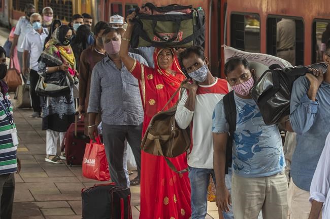 Travelers wait in queue to get tested for COVID-19 at a train station in Mumbai, India, Thursday, Sept. 30, 2021. (AP Photo/Rafiq Maqbool)