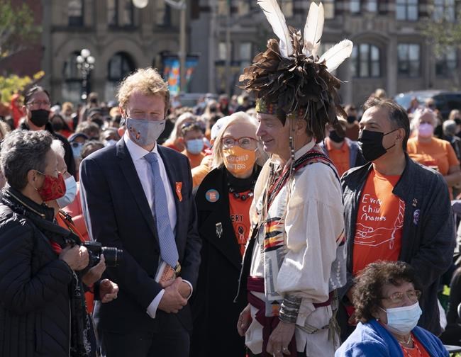 Doug George-Kanentiio, front centre, speaks with a woman as former Assembly of First Nations Chief Perry Bellegarde, rear right to left, Crown-Indigenous Relations Minister Carolyn Bennett and Indigenous Services Minister Marc Miller look on during the National Day of Truth and Reconciliation, Thursday, September 30, 2021 in Ottawa. THE CANADIAN PRESS/Adrian Wyld