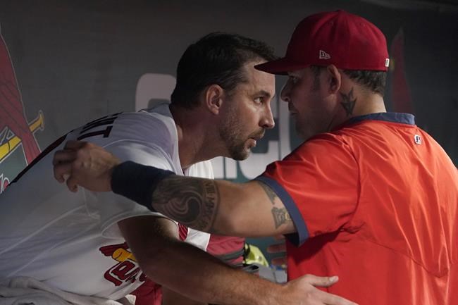 St. Louis Cardinals starting pitcher Adam Wainwright, left, gets a hug from teammate Yadier Molina after working during the sixth inning of a baseball game against the Milwaukee Brewers Tuesday, Sept. 28, 2021, in St. Louis. (AP Photo/Jeff Roberson)