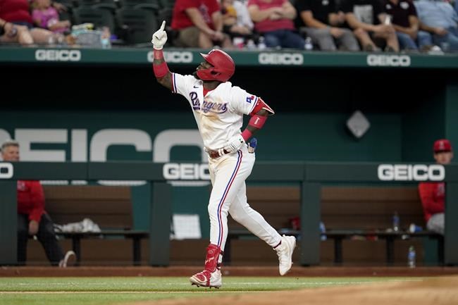 Texas Rangers' Adolis Garcia celebrates his two-run home run as he rounds the bases after in the fifth inning of a baseball game against the Los Angeles Angels in Arlington, Texas, Thursday, Sept. 30, 2021. Andy Ibanez also scored on the hit. (AP Photo/Tony Gutierrez)