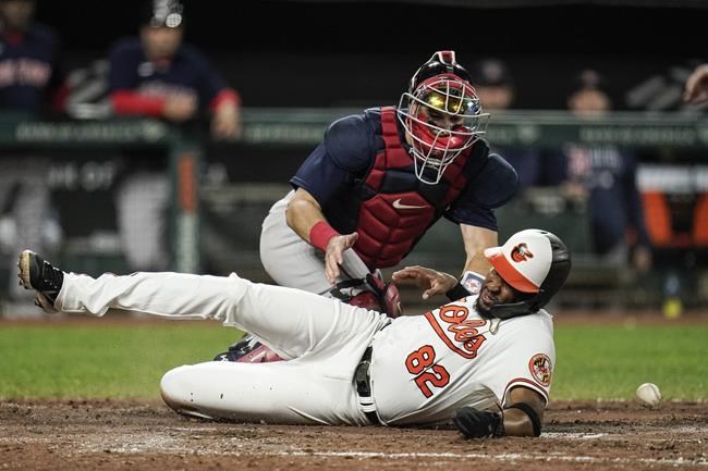 Baltimore Orioles' Kelvin Gutierrez (82) scores as Boston Red Sox catcher Kevin Plawecki tries to field a throw during the sixth inning of a baseball game, Thursday, Sept. 30, 2021, in Baltimore. (AP Photo/Julio Cortez)