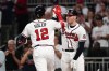 Atlanta Braves' Jorge Soler, left, is met by Freddie Freeman, right, after Soler hits a solo home run in the first inning of a baseball game against the Philadelphia Phillies, Thursday, Sept. 30, 2021, in Atlanta. (AP Photo/John Bazemore)