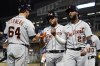 Detroit Tigers' Niko Goodrum (28), Jeimer Candelario, center, and Harold Castro (30) are greeted by Dustin Garneau (64) following Goodrum's three run home run off Minnesota Twins pitcher Joe Ryan in the fourth inning of a baseball game, Thursday, Sept. 30, 2021, in Minneapolis. (AP Photo/Jim Mone)