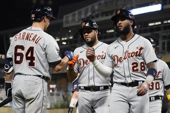 Detroit Tigers' Niko Goodrum (28), Jeimer Candelario, center, and Harold Castro (30) are greeted by Dustin Garneau (64) following Goodrum's three run home run off Minnesota Twins pitcher Joe Ryan in the fourth inning of a baseball game, Thursday, Sept. 30, 2021, in Minneapolis. (AP Photo/Jim Mone)