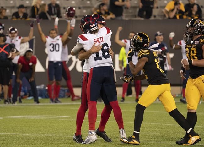 Montreal Alouettes kicker David Ct頨15) is hugged by Montreal Alouettes quarterback Matthew Shiltz (18) after his game-winning field goal during overtime CFL football game action against the Hamilton Tiger Cats in Hamilton, Ont. on Saturday, October 2, 2021. THE CANADIAN PRESS/Peter Power
