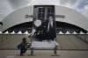 A woman places flowers to Bernard Tapie outside the Orange Velodrome stadium in Marseille, southern France, Sunday, Oct. 3, 2021. Bernard Tapie, the charismatic president of French soccer club Marseille during its glory era whose reign was marred by a match-fixing scandal, has died, Sunday Oct. 3, 2021. He was 78. (AP Photo/Daniel Cole)