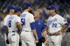 Kansas City Royals trainer Nick Kenny, second from right, and manager Mike Matheny (22) talk to starting pitcher Brady Singer before taking him out of the game during the first inning of a baseball game against the Cleveland Indians Tuesday, Sept. 28, 2021, in Kansas City, Mo. (AP Photo/Charlie Riedel)