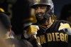 San Diego Padres' Fernando Tatis Jr. celebrates in the dugout after hitting a home run during the fifth inning of a baseball game against the Los Angeles Dodgers Thursday, Sept. 30, 2021, in Los Angeles. Webster Rivas also scored. (AP Photo/Ashley Landis)