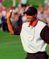 FILE - In this Oct. 6, 1996, file photo, Tiger Woods reacts to the crowd on the 18th green at TPC at Summerlin after shooting a 27-under-par during the Las Vegas Invitational golf tournament in Las Vegas. Twenty-five years ago this week Woods won for the first time on the PGA Tour at the Las Vegas Invitational, changing golf forever. (AP Photo/Lennox McLendon, File)