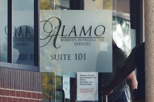 A woman enters Alamo Women's Reproductive Services, Thursday, Oct. 7, 2021, in San Antonio. A federal judge ordered Texas to suspend the most restrictive abortion law in the U.S., calling it an