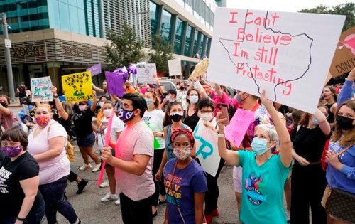 FILE - In this Oct. 2, 2021 file photo people participate in the Houston Women's March against Texas abortion ban walk from Discovery Green to City Hall in Houston. A federal appeals court is temporarily allowing the nation’s toughest abortion law to resume in Texas. The 5th U.S. Circuit Court of Appeals handed down the order Friday, Oct. 8. (Melissa Phillip/Houston Chronicle via AP, File)