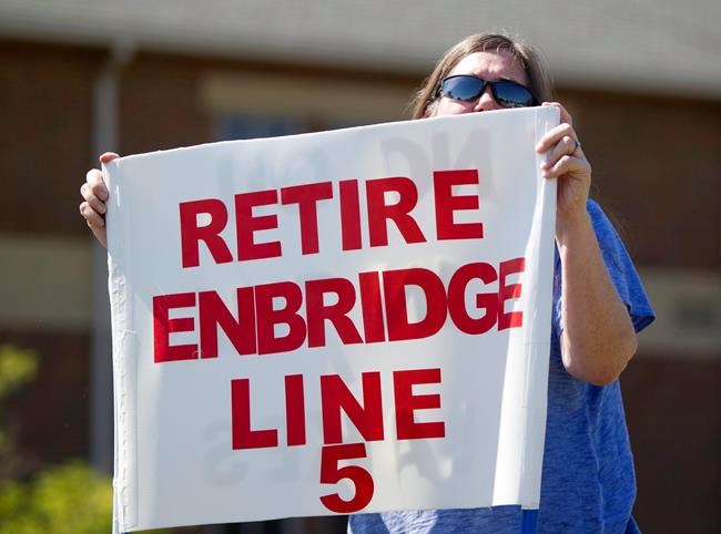In this Thursday, July 6, 2017, file photo, Lauren Sargent, of Ann Arbor, Mich., takes part in a protest before the Enbridge Line 5 pipeline public information session at Holt High School in Holt, Mich. THE CANADIAN PRESS/AP-Cory Morse/The Grand Rapids Press via AP, File