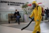 An employee of the Federal State Center for Special Risk Rescue Operations of Russia Emergency Situations disinfects Leningradsky railway station in Moscow, Russia, Tuesday, Oct. 19, 2021, with the sign reading 