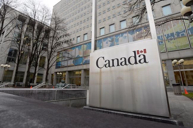A Government of Canada sign sits in front of a Library and Archives Canada building next to Parliament Hill in Ottawa on Tuesday Nov. 25, 2014. Researchers say service cuts at Canada's national archives are making their work — already hampered by COVID-19 — even more challenging. THE CANADIAN PRESS/Adrian Wyld