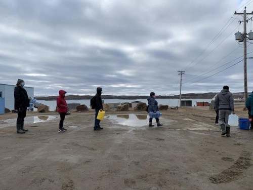 Residents line up to fill containers with potable water in Iqaluit on Thursday, Oct. 14, 2021. The city is set to provide an update today on the results of additional water testing. Its 8,000 or so residents haven't been able to consume tap water for 11 days after it was discovered to contain fuel. THE CANADIAN PRESS/Emma Tranter