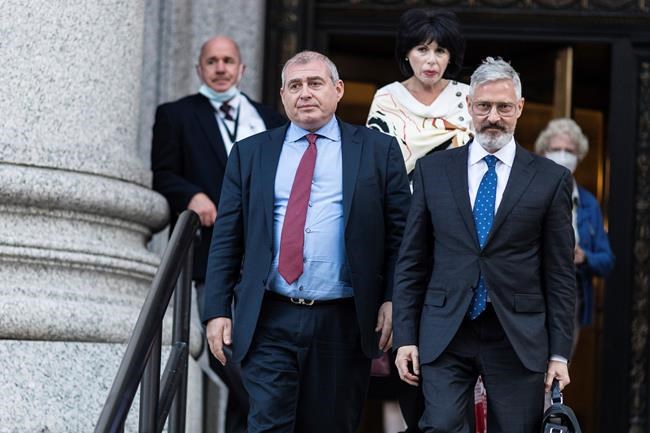 ADDS NAME LUDA PARNAS - Lev Parnas, left, and his lawyer Joseph Bondy leave federal court following closing arguments in his trial, Thursday, Oct. 21, 2021, in New York. Parnas, an associate of Rudy Giuliani, hatched a scheme to funnel $1 million in funds from a wealthy Russian financier into U.S. elections knowing full well he was breaking campaign finance laws, a prosecutor said during closing arguments. Parnas' sister, Luda Parnas, top center, looks on. (AP Photo/Stefan Jeremiah)