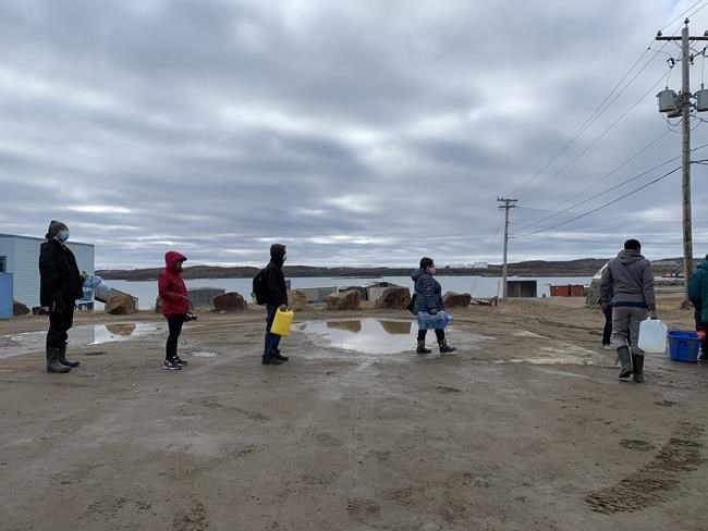 Residents line up to fill containers with potable water in Iqaluit, Nunavut on Thursday, Oct. 14, 2021. Iqaluit residents could get a break on their water bills as they continue to deal with fuel contamination that's prevented them from being able to drink their tap water. THE CANADIAN PRESS/Emma Tranter