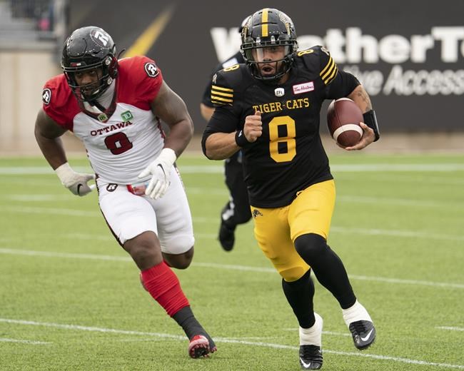 Hamilton Tiger Cats quarterback Jeremiah Masoli (8) scrambles from Ottawa Redblacks defensive back Don Unamba (0) during first half CFL football game action in Hamilton, Ont., Saturday, Oct. 23, 2021. THE CANADIAN PRESS/Peter Power