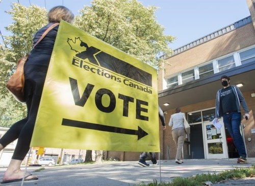 People arrive to cast their ballot on federal election day in Montreal, Monday, Sept. 20, 2021. Elections Canada was curious to know how many Canadians believed in conspiracy theories leading up to the recent federal vote. THE CANADIAN PRESS/Graham Hughes