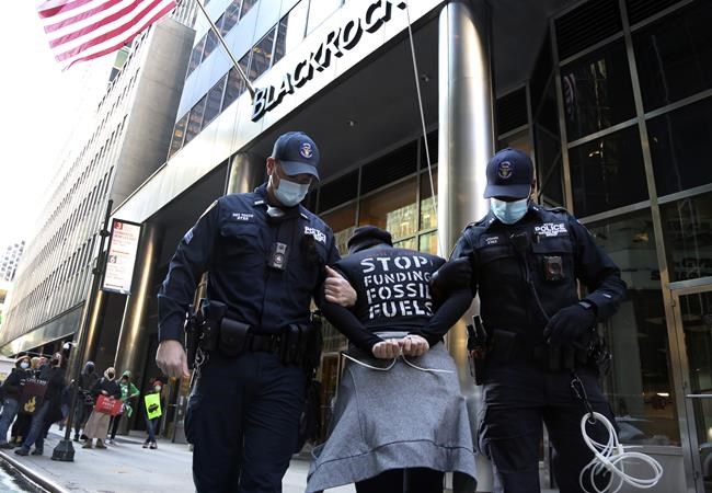 Climate activist Rev. Chelsea McMillan, center, is arrested after an interfaith demonstration outside the headquarters of BlackRock, a multinational investment management corporation, in New York City on Monday, Oct. 18, 2021. The protest was one of more than 500 actions in the Faiths for Climate Justice global mobilization, held two weeks prior to the United Nations Climate Change Conference. (AP Photo/Jessie Wardarski)