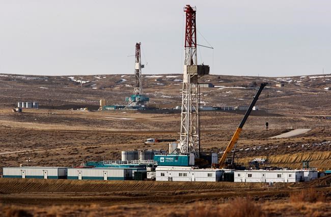 FILE- In this March 5, 2013, file photo, Trinidad Drilling rigs are seen off of Way Highway 59 outside of Douglas, Wyo. The Interior Department is preparing to offer oil and gas lease sales on large tracts of public land despite concluding that burning fossil fuels from those parcels could carry huge costs and contribute to climate change. (Leah Millis/The Casper Star-Tribune via AP, File)