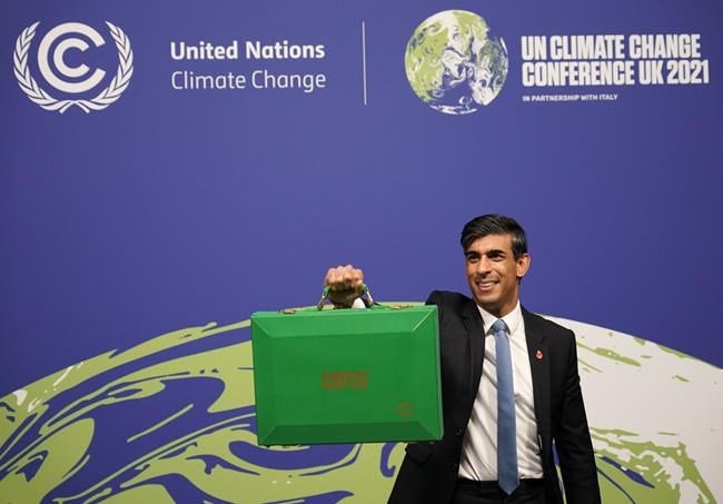Britain's Chancellor of the Exchequer Rishi Sunak holds up a Green briefcase as he arrives for a speech at the COP26 U.N. Climate Summit in Glasgow, Scotland, Wednesday, Nov. 3, 2021. The British government plans to make the U.K.
