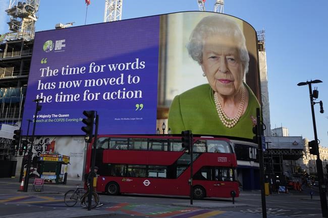 A picture and quotation taken from Britain's Queen Elizabeth II's address to COP26 delegates as she appears as a domination on the Piccadilly Lights, at Piccadilly Circus in London, Wednesday, Nov. 3, 2021. (AP Photo/Kirsty Wigglesworth)