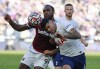 West Ham's Michail Antonio, left, challenges for the ball with Tottenham's Cristian Romero during the English Premier League soccer match between West Ham United and Tottenham Hotspur at the London stadium in London, England, Sunday, Oct. 24, 2021. (AP Photo/Ian Walton)