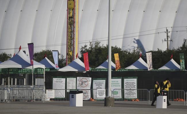 Security walks around the NRG lots where Astroworld was held the night before in Houston on Saturday, Nov. 6, 2021. Several people died and numerous others were injured in what officials described as a surge of the crowd at the music festival while Travis Scott was performing. (Elizabeth Conley/Houston Chronicle via AP)