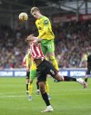 Brentford's Ethan Pinnock, left and Norwich City's Brandon Williams battle for the ball, during the English Premier League soccer match between Brentford and Norwich City, at Brentford Community Stadium, in London, Saturday, Nov. 6, 2021. (John Walton/PA via AP)