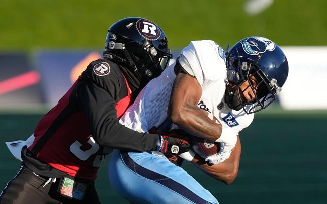 Toronto Argonauts wide receiver Kurleigh Gittens Jr., right, is tackled by Ottawa Redblacks defensive back Ranthony Texada during first half CFL action, Saturday, November 6, 2021 in Ottawa. THE CANADIAN PRESS/Adrian Wyld
