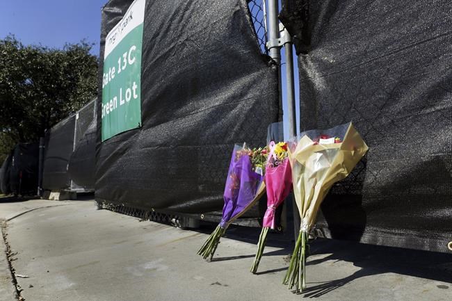 Flowers lie against the south fence surrounding the Astroworld festival grounds the day after several people died and scores were injured during a concert the night before at NRG Park, Saturday, Nov. 6, 2021, in Houston. (AP Photo/Michael Wyke)