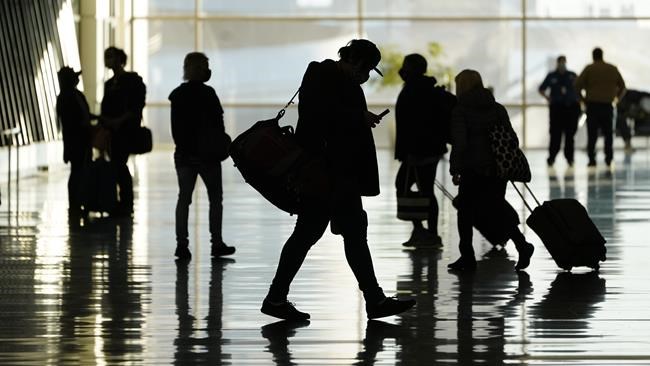 FILE - Passengers walk through Salt Lake City International Airport in Salt Lake City, Oct. 27, 2020. More than a year and a half after COVID-19 concerns prompted the U.S. to close its borders to international travelers from countries including Brazil, China, India, South Africa, the United Kingdom and much of Europe, restrictions are shifting to focus on vaccine status. Beginning Monday, bans on travel from specific countries are over. The U.S. will allow in international travelers, but they must be vaccinated — with a few exceptions. (AP Photo/Rick Bowmer, File)