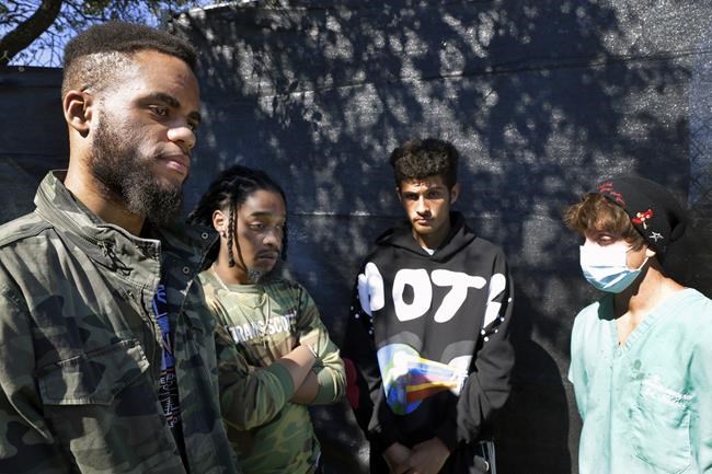 Festival attendants, from left, Brandon Beauval, Joshua Robinson, Andrew Diaz and Billy Nasser talk about their experiences after several people died and scores were injured during the music festival the night before, Saturday, Nov. 6, 2021, in Houston. (AP Photo/Michael Wyke)