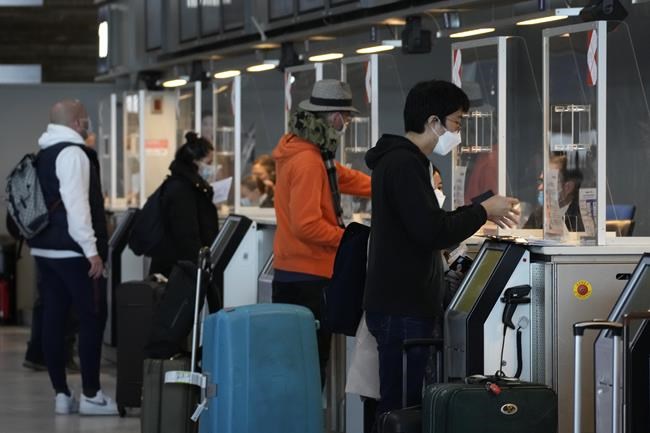 Travelers for the United States show their documents at the check-in desk at Charles de Gaulle airport, north of Paris, Monday, Nov.8, 2021. The U.S. lifted restrictions Monday on travel from a long list of countries including Mexico, Canada and most of Europe, allowing tourists to make long-delayed trips and family members to reconnect with loved ones after more than a year and a half apart because of the pandemic. (AP Photo/Christophe Ena)