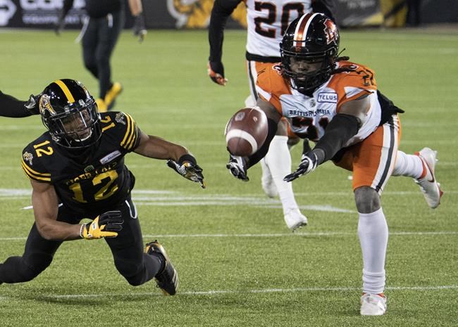 Hamilton Tiger Cats wide receiver Tim White (12) and B.C. Lions linebacker Jordan Williams (21) dive for a loose ball during second half CFL football game action in Hamilton, Ont. on Friday, November 5, 2021. THE CANADIAN PRESS/Peter Power