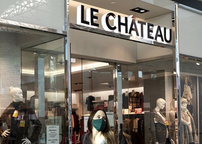 A woman in a face mask exits Le Chateau at the Guildford Town Centre in Surrey, B.C., on December 4, 2020. THE CANADIAN PRESS/Marissa Tiel