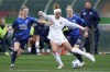 Washington Spirit forward Trinity Rodman, center, kicks the ball between OL Reign's defender Kristen McNabb, left, and midfielder Jess Fishlock in the semifinals of the NWSL soccer playoffs Sunday, Nov. 14, 2021, in Tacoma, Wash. (AP Photo/Elaine Thompson)