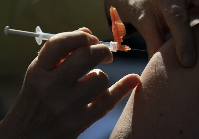 A dose of the Pfizer-BioNTech vaccine is given to a recipient at a vaccination site in Vancouver Thursday, March 11, 2021. The federal government is set to make two major announcement on the pandemic front Friday, starting with the approval of Canada's first COVID-19 vaccine for children, then later detailed plans to ease some of the pandemic-related measures at the border. THE CANADIAN PRESS/Jonathan Hayward