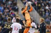 Philadelphia Union's Andre Blake, center, leaps up to make the save during the first half of an MLS playoff soccer match against the New York Red Bulls, Saturday, Nov. 20, 2021, in Chester, Pa. (AP Photo/Chris Szagola)