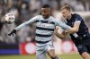 Sporting Kansas City forward Khiry Shelton (11) and Vancouver Whitecaps midfielder Andy Rose, right, chase the ball during the first half of an MLS soccer match, Saturday, Nov. 20, 2021, in Kansas City, Kan. (AP Photo/Charlie Riedel)