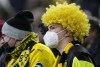 FILE - A Dortmund supporter wears a face mask due to the coronavirus pandemic on the tribune prior the German Bundesliga soccer match between Borussia Dortmund and VfB Stuttgart in Dortmund, Germany, Saturday, Nov. 20, 2021. Canceled games, players in quarantine, arguments over vaccine mandates. Sports in Germany are facing a winter of discontent and disruption as the country endures a fourth wave of spiraling coronavirus infections. (AP Photo/Martin Meissner, File)