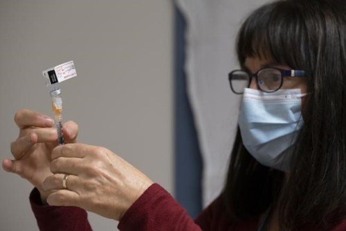 The Saskatchewan Health Authority has resumed nearly 50 per cent of the health-care services it cut during the province's fourth wave, but high hospitalization rates in urban areas are preventing the remaining services from returning. Heather Witzel-Garnhum, nurse clinician, prepares a syringe with the Pfizer-BioNTech COVID-19 vaccine at the Regina General Hospital in Regina on Tuesday Dec. 15, 2020. THE CANADIAN PRESS/Michael Bell