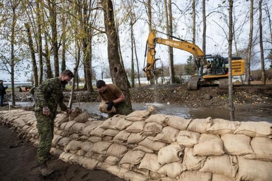 Members of the Canadian Forces build a temporary dike with sandbags behind houses on Clayburn Creek ahead of a rainfall warning Environment Canada has forecast for the region which is already affected by flooding, in Abbotsford, B.C., on Wednesday, Nov. 24, 2021. THE CANADIAN PRESS/Darryl Dyck