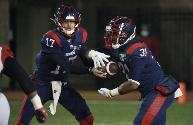 Montreal Alouettes quarterback Trevor Harris hands off to Alouettes running back William Stanback as they face the Ottawa Redblacks during first quarter CFL football action in Montreal on Friday, November 19, 2021. THE CANADIAN PRESS/Paul Chiasson
