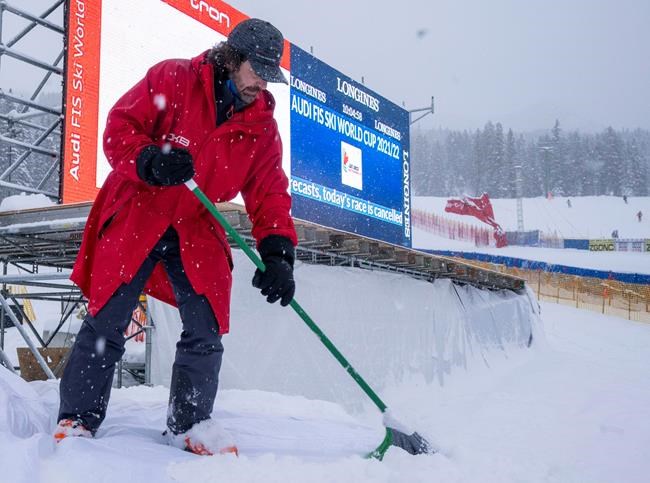 A course worker sweeps snow following the cancelation of the FIS World Cup Super-G ski race in Lake Louise, Alta., on Sunday, November 28, 2021. The race was cancelled due to too much snow on the course. THE CANADIAN PRESS/Frank Gunn