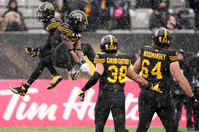 Hamilton Tiger-Cats running back Don Jackson (5) celebrates his touchdown with wide receiver Tim White (12) during first half CFL division semi-final football action against the Montreal Alouettes in Hamilton, Ont., on Sunday, November 28, 2021. THE CANADIAN PRESS/Nathan Denette